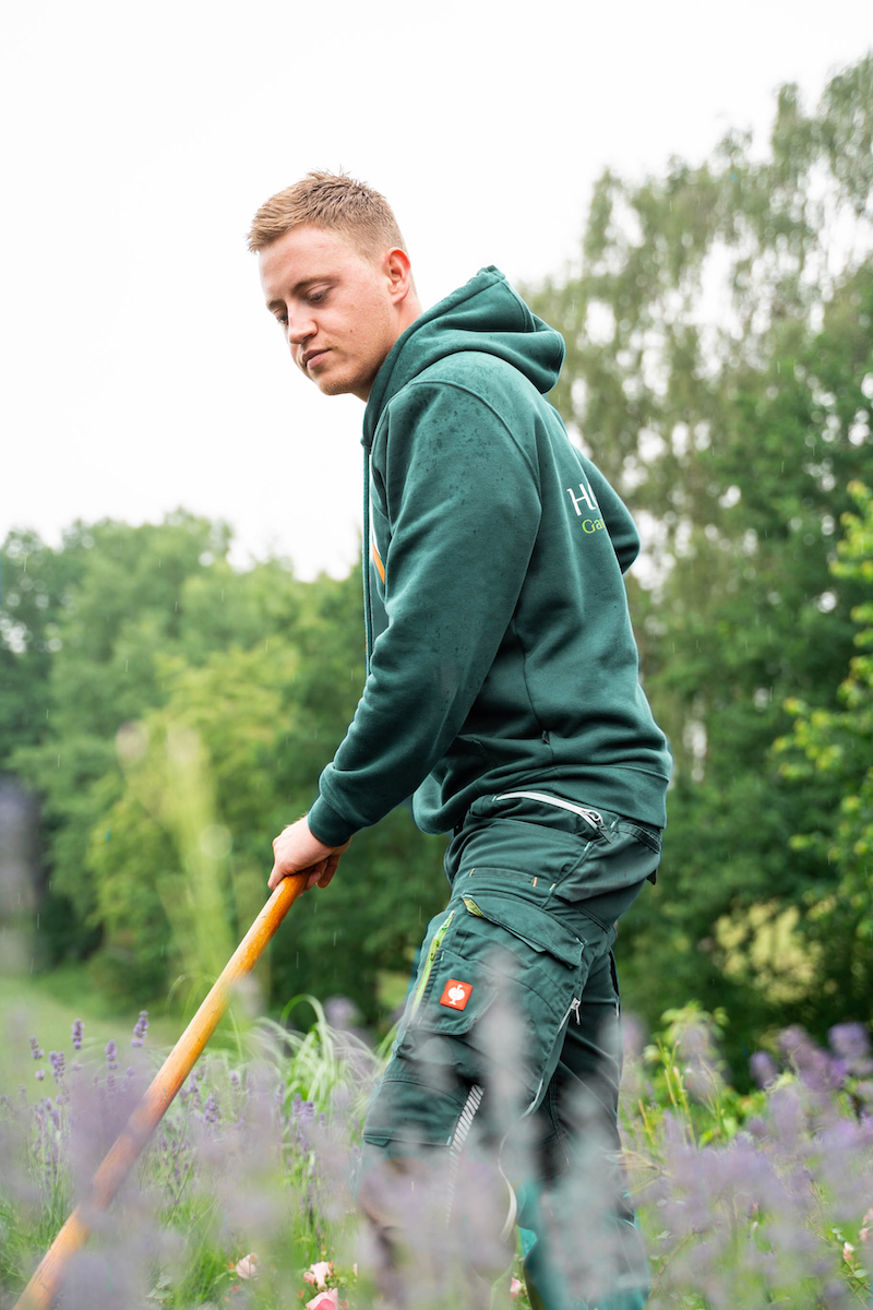 Junger Gärtner beim Beete Harken